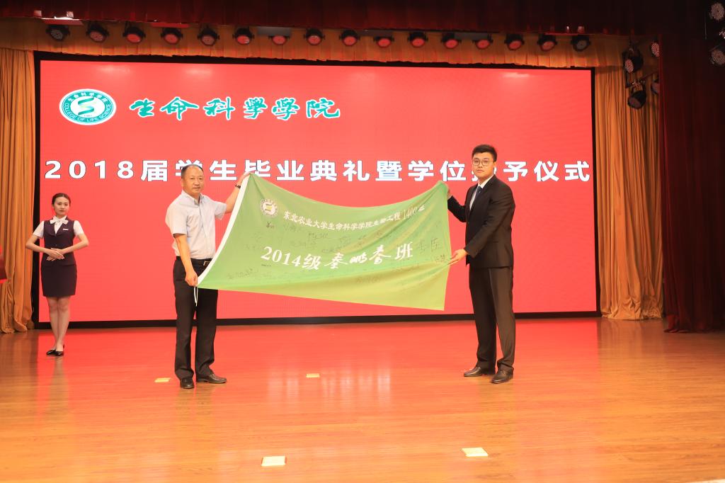 欧洲杯正规买球平台党委书记施喜军代表学院接受2014级秦鹏春班代表敬献的签字班旗