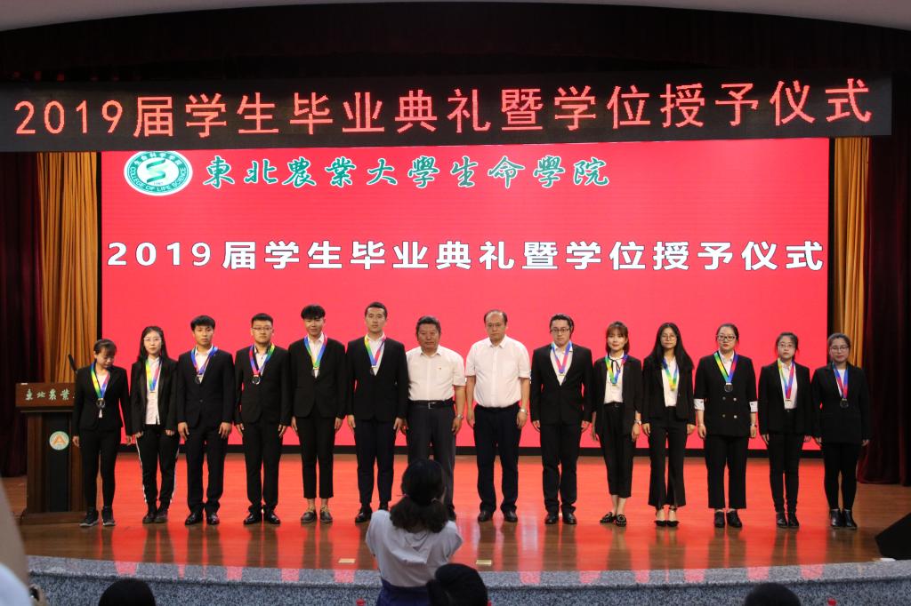 教务处处长王杜春、研究生院副院长彭胜民为2019届优秀毕业生颁发纪念奖牌
